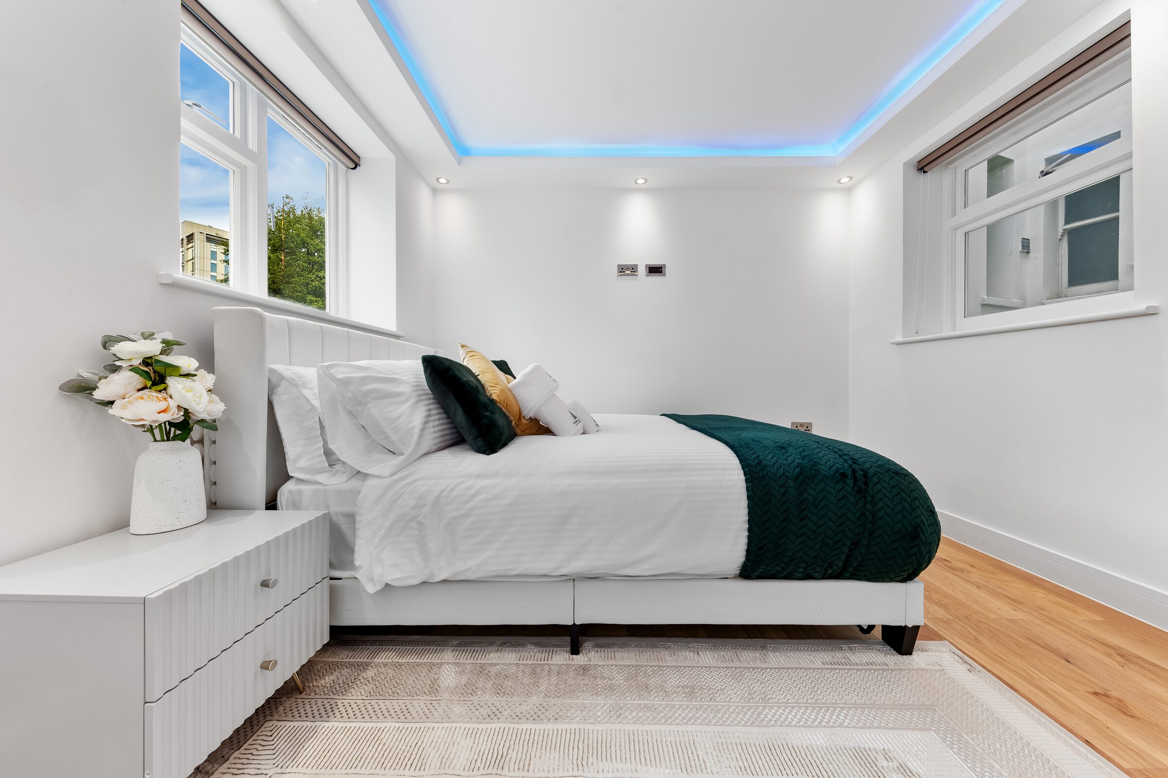 Double bed with green throws