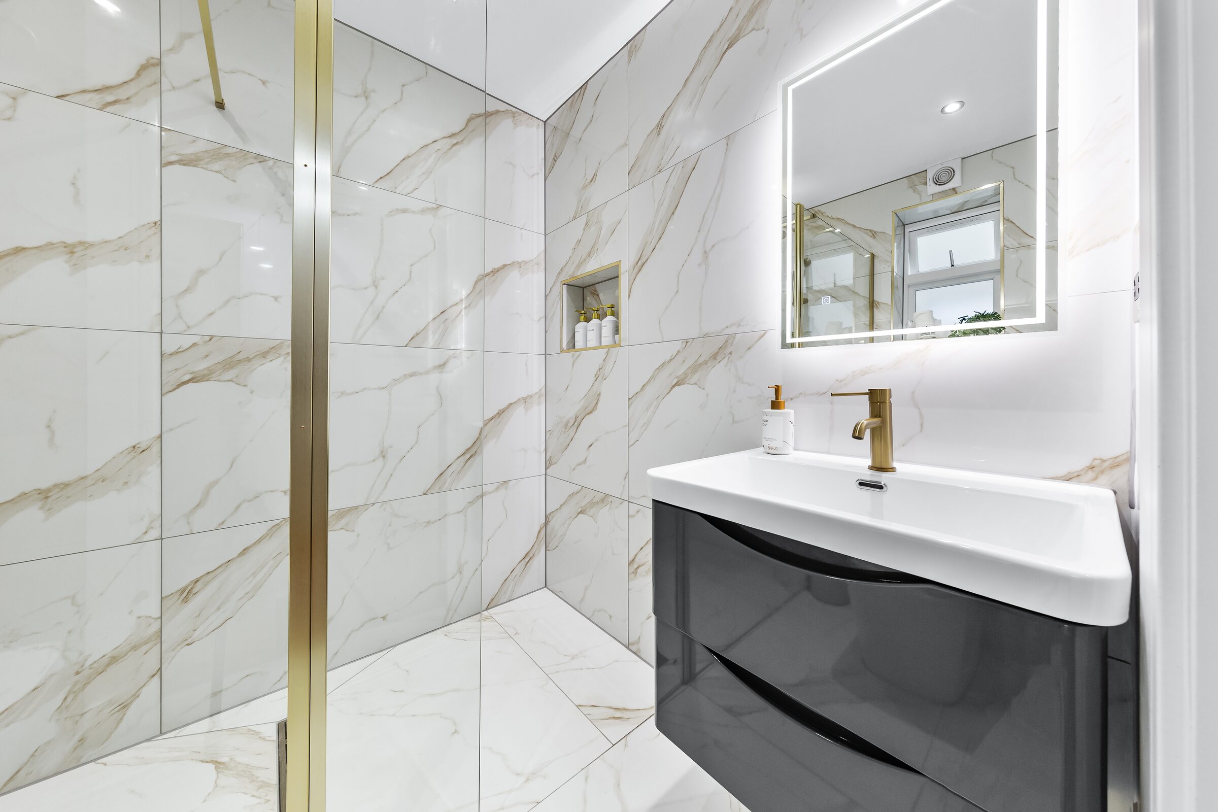 Marble bathroom — rain shower and gold fittings