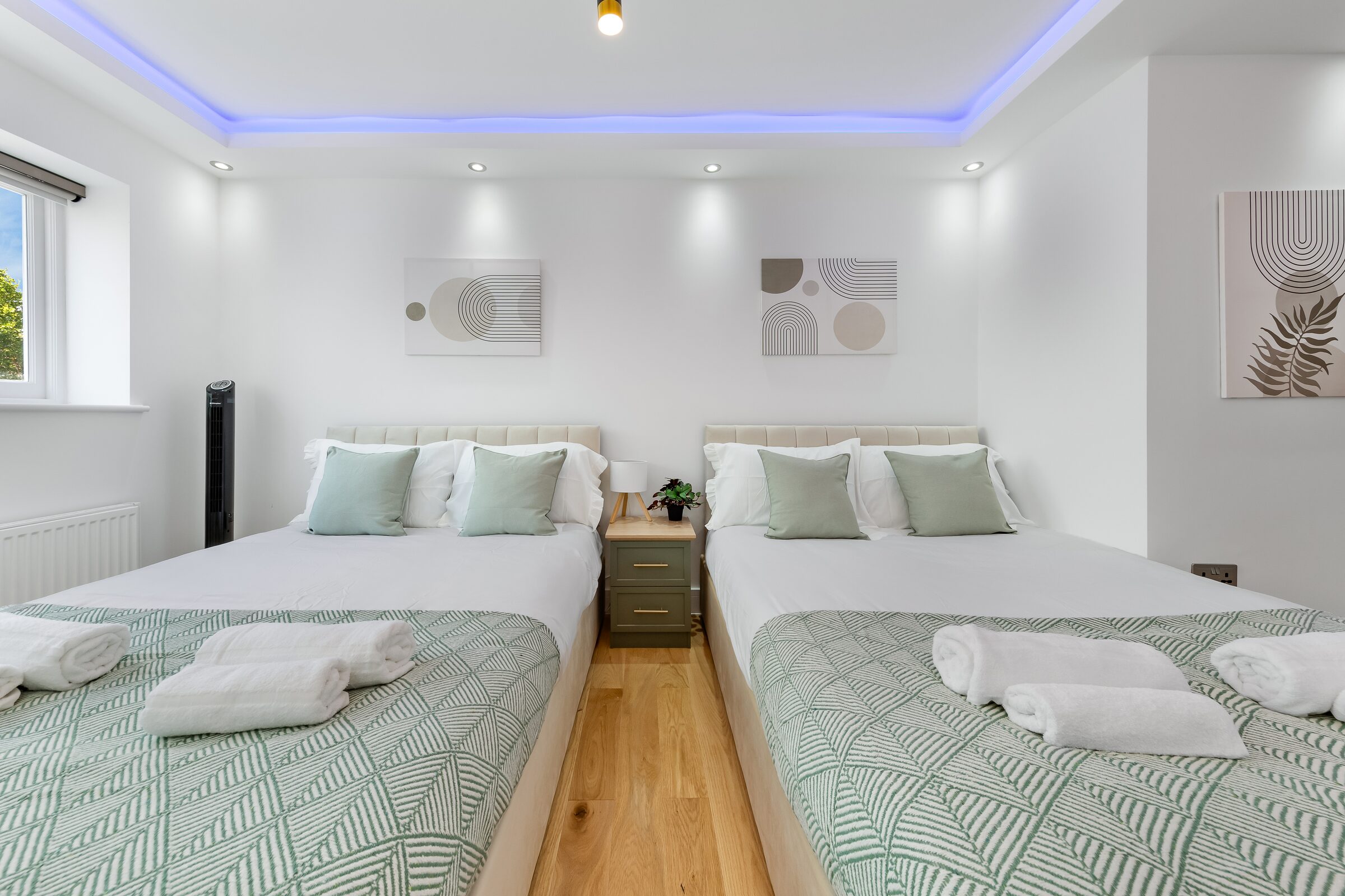 Bedroom 1 — twin beds with sage green throws