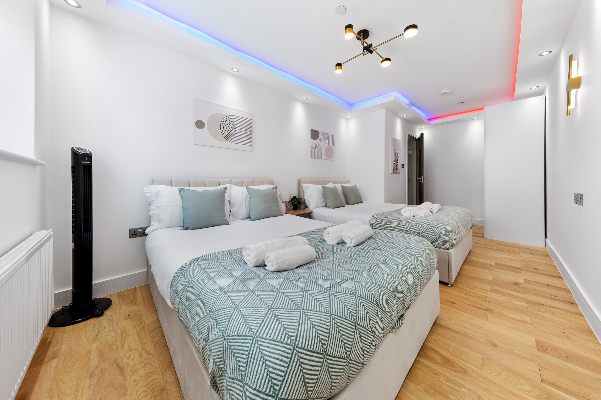 Bedroom 1 — beds and tower fan