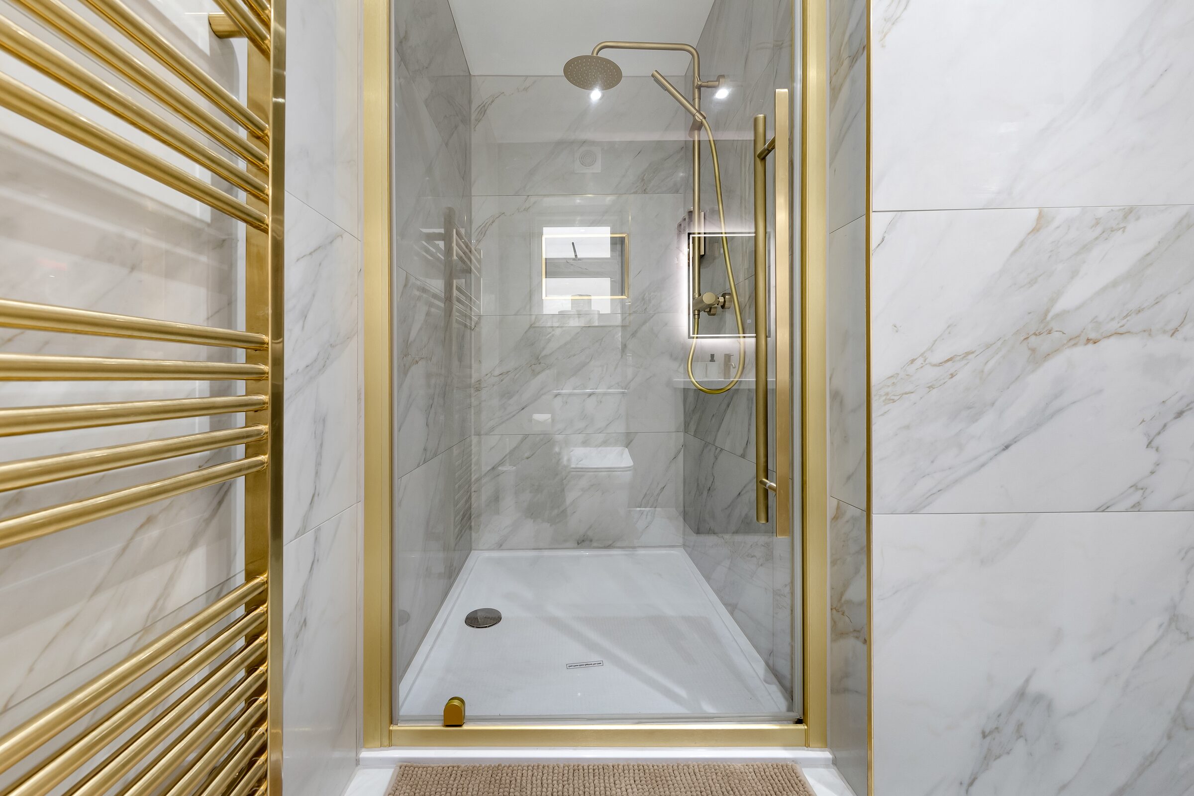 Marble rain shower with gold fittings